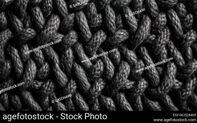 This photo showcases a close-up macro texture of black wool textile material with an intricate wicker pattern, shot from a top-down perspective