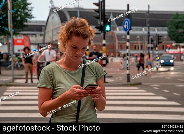 A young woman travels with her phone to discover new places of interest in the world. Photo and online navigation on smartphone