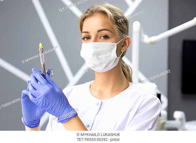 Dental assistant holding syringe