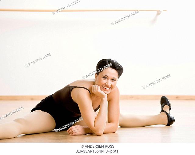 Tap dancer stretching on studio floor
