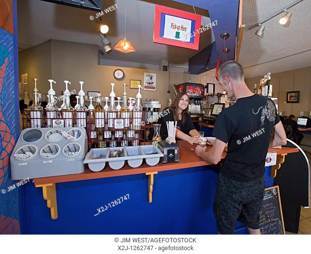 Alamosa, Colorado - An Americorps volunteer serves a drink to a customer at Milagros Coffee House  Profits from the coffee house support La Puente