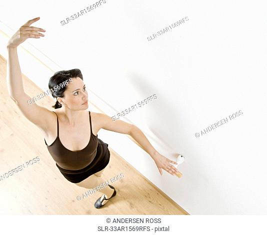 Dancer posing at barre in studio