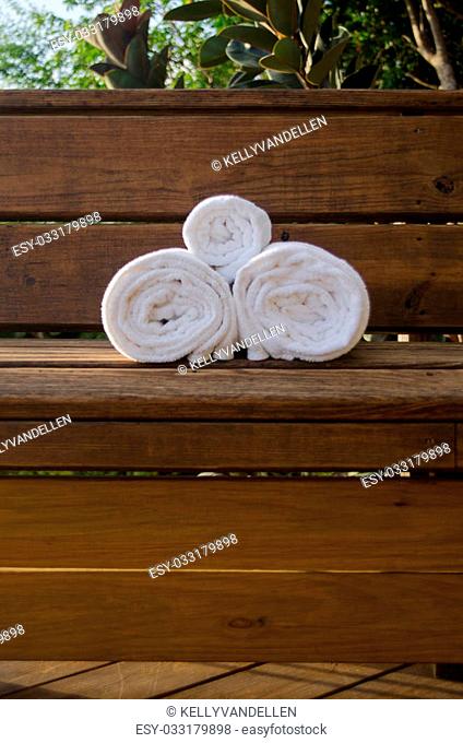 Towels sit on a wooden bench offering vacationers a spa like setting for rest and relaxation