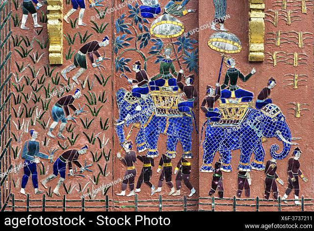 Scenes from rural life as mosaic decorations on an outer wall of the Tripitaka library, Wat Xieng Thong temple, Luang Prabang, Laos