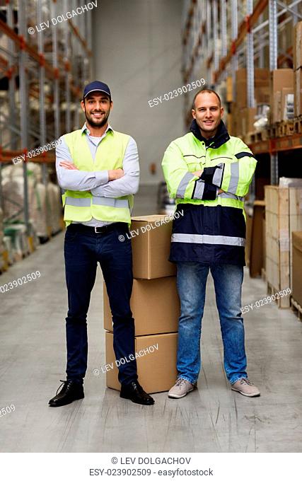 logistic, delivery, shipment, people and export concept - happy men or manual workers with boxes at warehouse