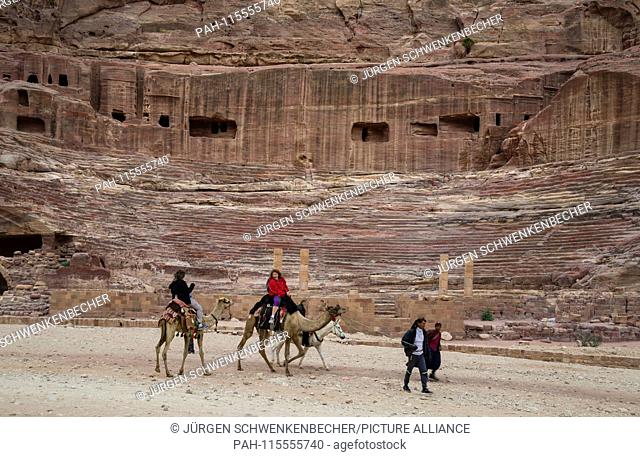 amels carry tourists along the long paths in the rock town of Petra. The theatre, which once accommodated 7, 000 people, is part of the extensive complex
