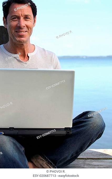 Man using a laptop computer on the waterfront
