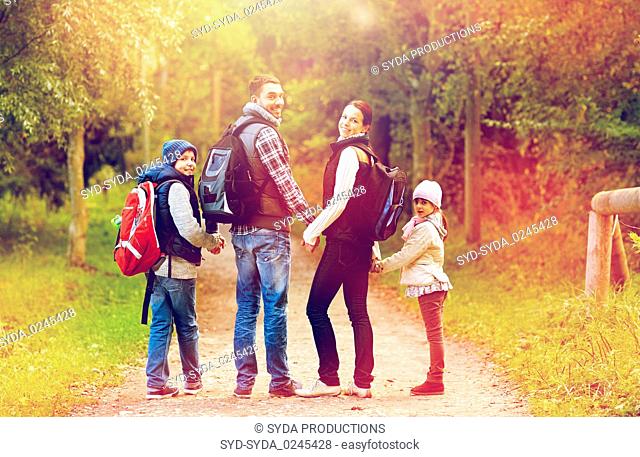 happy family with backpacks hiking walking