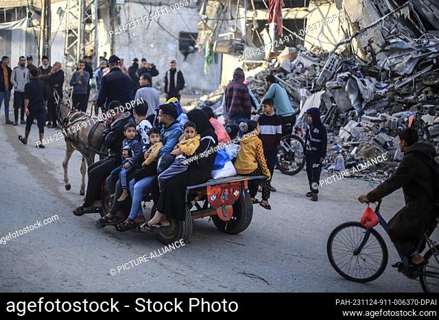 24 November 2023, Palestinian Territories, Khan Yunis: Donkeys carry Palestinian families who had taken refuge in temporary shelters