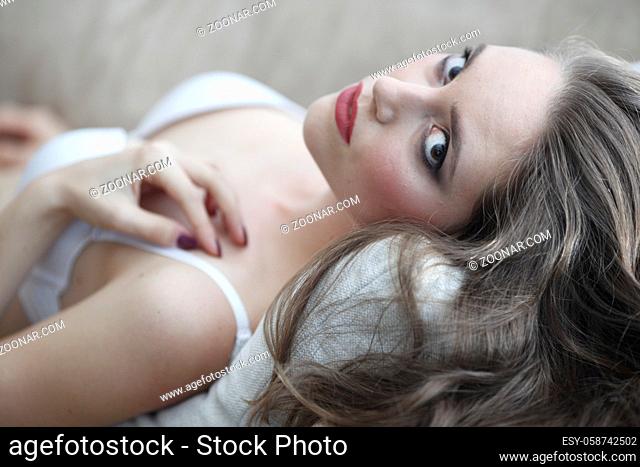 Portrait of beautiful young woman in lingerie on sofa