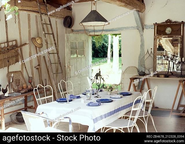 Table and chairs set for dinner with blue tableware in country style dining room