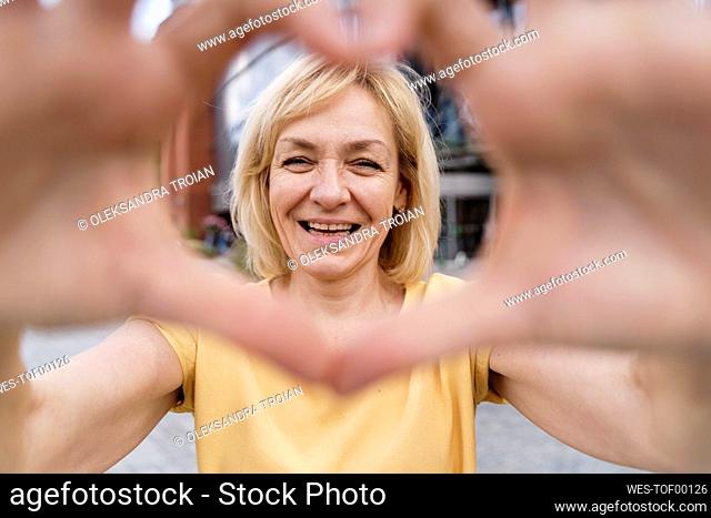 Happy woman making heart shape with hands