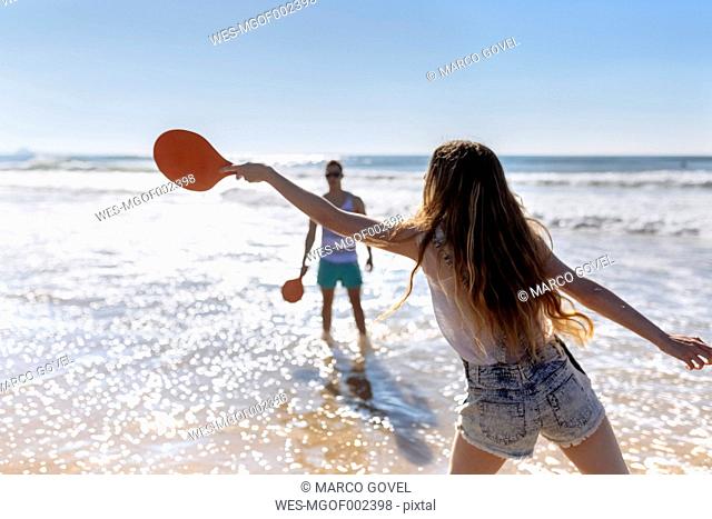 Back view of teenage girl playing beach paddles on the beach