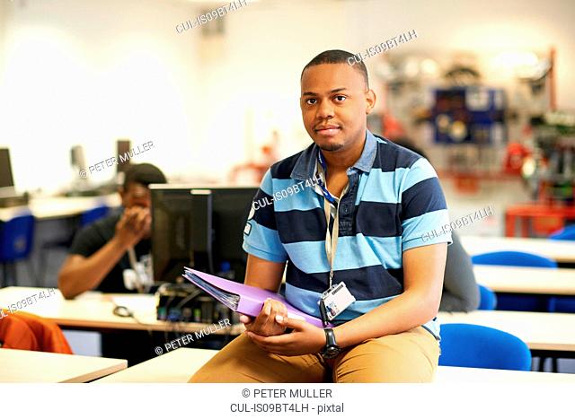 Young male higher education student in college classroom, portrait