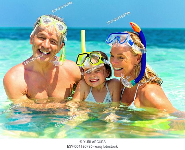 Portrait of happy family in ocean water ready to snorkel - Enjoying vacations