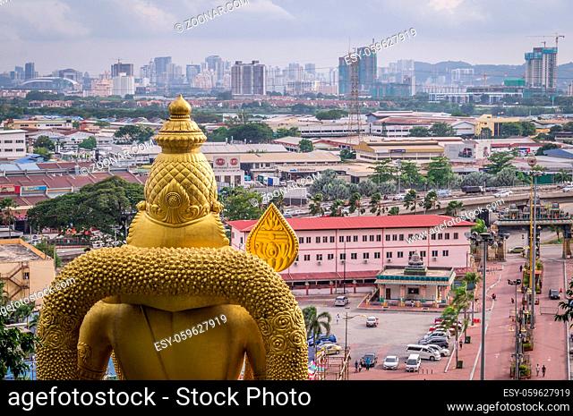 View on Kuala Lumpur skyline with golden statue from batu caves temple, Malaysia