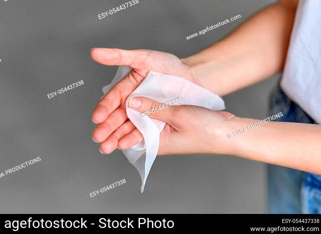 woman cleaning hands with antiseptic wet wipe