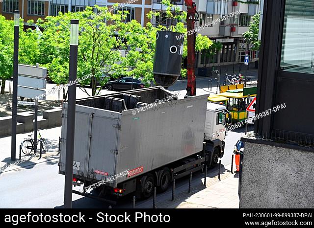 30 May 2023, North Rhine-Westphalia, Cologne: A container for waste glass is emptied into a truck Photo: Horst Galuschka/dpa/Horst Galuschka dpa