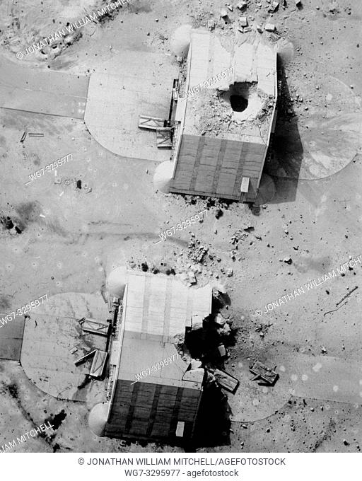 IRAQ -- 11 Mar 1991 -- Two reinforced concrete aircraft hangars at the Ahmed Al Jaber Airfield show the results of a coalition bombing strike during Operation...