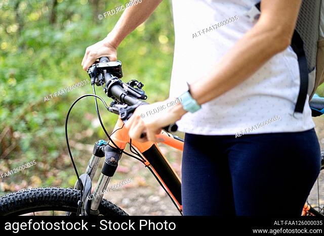 Close-up of mature woman holding bicycle