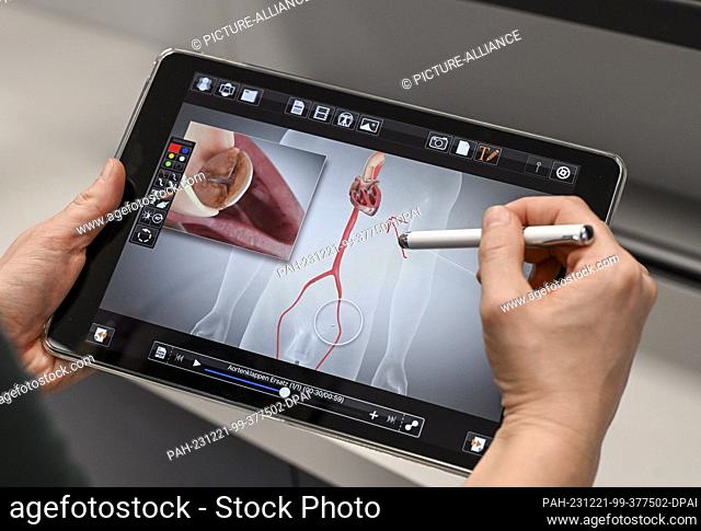 PRODUCTION - 13 December 2023, Berlin: A digital tool is shown on a tablet in the e-health show practice of the Berlin Association of Statutory Health Insurance...