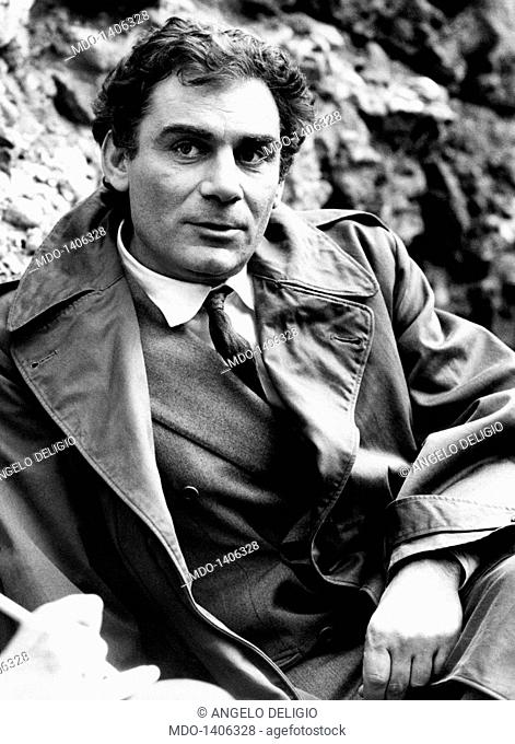 Gian Maria Volontè seated with a the raincoat. Italian actor Gian Maria Volontè wears a raincoat and relaxes himself during a break on the set of the movie...