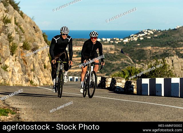 Cyclists cycling at Costa Blanca mountain pass on sunny day in Alicante, Spain