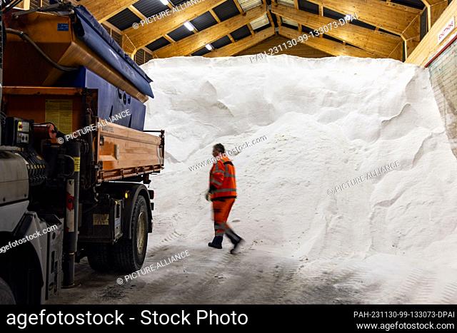30 November 2023, North Rhine-Westphalia, Lüdenscheid: An Autobahn GmbH employee in the large salt store at the highway maintenance depot