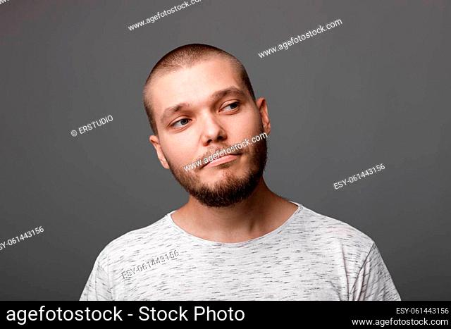 portrait of sad young man on gray background. regret