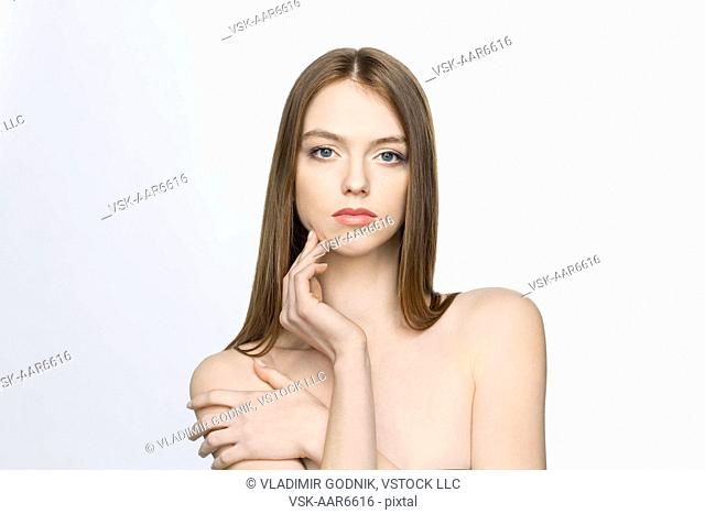 Portrait of shirtless young woman on white background