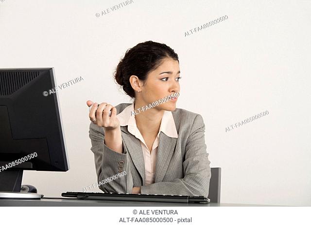 Young businesswoman holding yin g balls at desk
