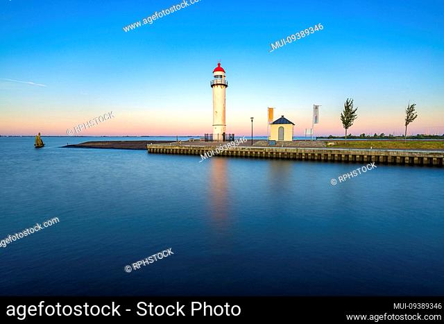 The lighthouse of the dutch village Hellevoetsluis in the provice south holland at sunrise on a warm summer day