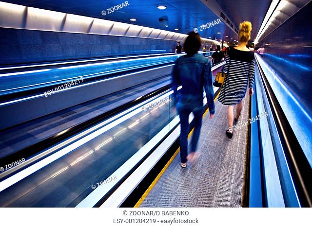 Blue moving escalator with people in Barcelona's subway