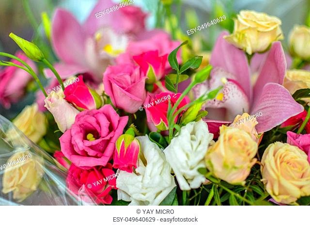 Bouquet with orchids and roses on a beautiful background closeup