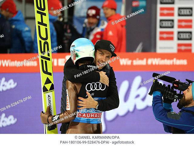 Kamil Stoch (L) of Poland embraces Sven Hannawald after his jump in the second round at the Four Hills Tournament in Bischofshofen, Austria, 6 January 2018
