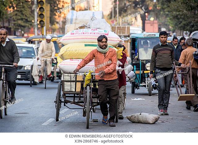 Johri Bazaar; Man pulls rickshaw full of rice in Jaipur, India