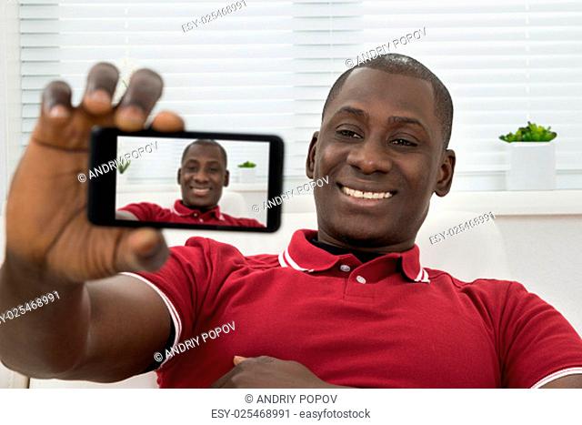 Close-up Of Young African Man Taking Selfie On Cellphone