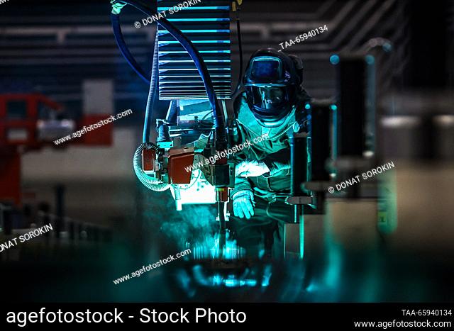 RUSSIA, SVERDLOVSK REGION - DECEMBER 19, 2023: A welder uses a robotic installation to manufacture a Lastochka ES104 high-speed electric train at the Ural...