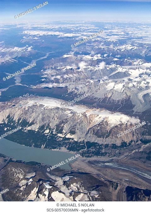 Aerial views of snow-capped mountains, ice fields, and glaciers on a commercial flight from Juneau to Anchorage Alaska, USA Pacific Ocean Alaska has hosted a...