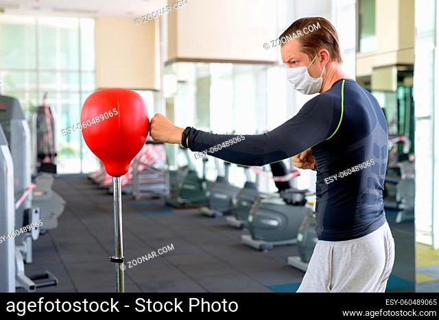 Portrait of young man at the gym with some exercise equipment use restricted for corona virus covid-19 safety measurements