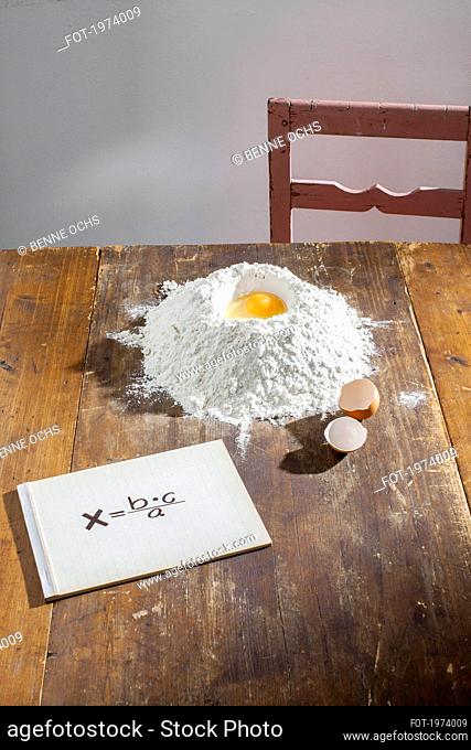 Egg inside flour nest on table with equation