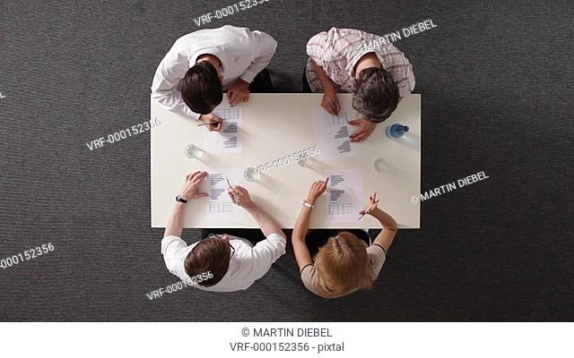 MS, four business people shaking hands after having a meeting, overhead view