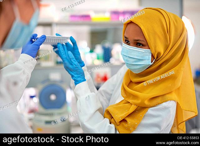 Female scientist in hijab and face mask working in laboratory