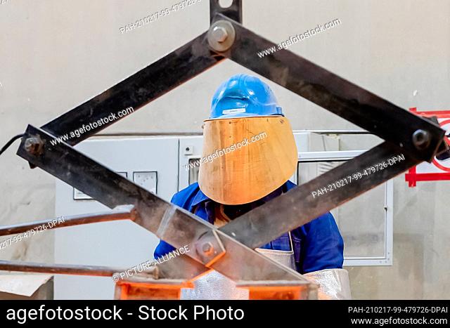 17 February 2021, Berlin: An employee of Bildgießerei Noack stands behind a crane wearing protective equipment while casting a Berlinale Bear