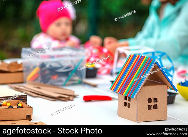 Creative children play with craft. Cute preschool children prepare together Paper decor. Tools and materials for children's art creativity on table on street