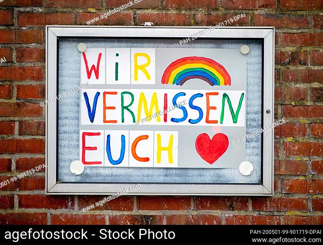 30 April 2020, Lower Saxony, Schüttorf: The painted lettering ""We miss you"" as well as a colourful rainbow and a heart are hanging in a display case at the...