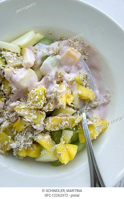 Muesli with oatmeal, mango, grapes and apples