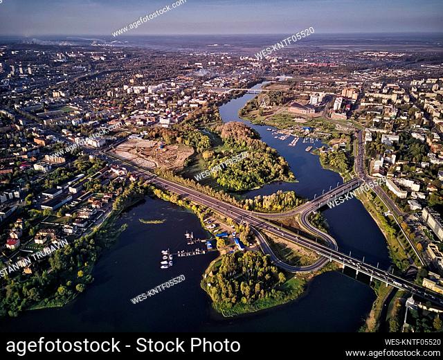 Kotorosl River with bridges amidst buildings in Yaroslavl, Russia, against sky