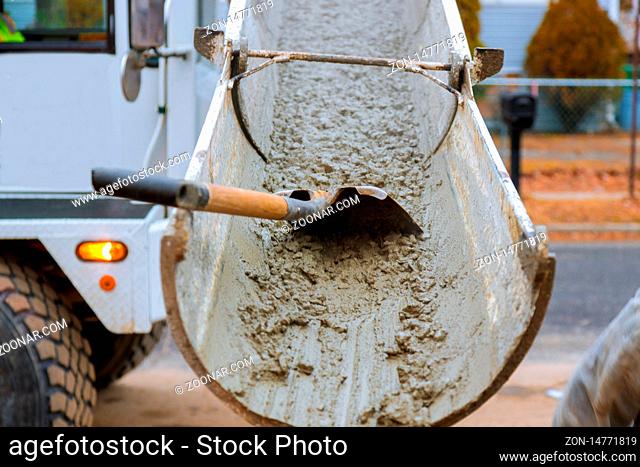 Concrete truck with pouring cement during to residential street selective focus