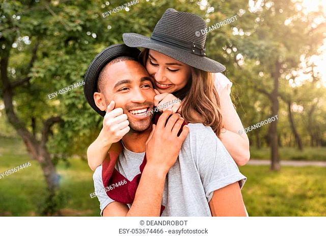 Smiling beautiful young couple in love having fun in park
